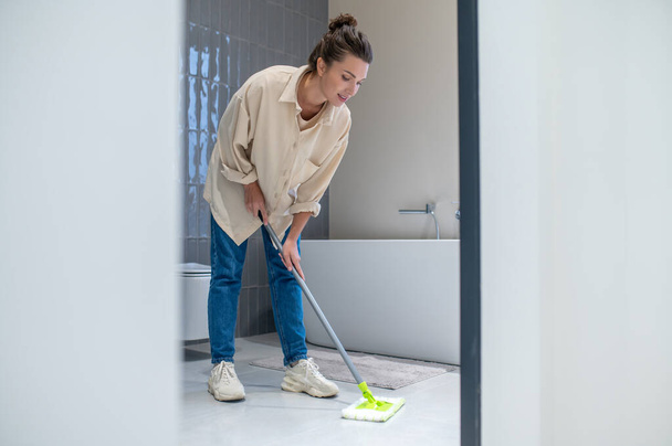 Young woman cleaning the floor at home - Foto, immagini