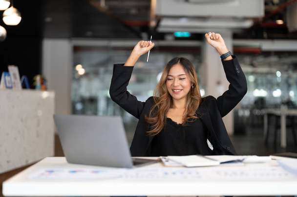 Muotokuva onnellinen nuori liike aasialainen nainen juhlii menestystä aseita ylös. positiivinen ilme, menestystä liiketoimintakonseptissa - Valokuva, kuva