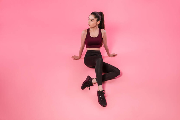 Fitness girl in leggings and top on pink background. Sport, healthy lifestyle. Full-length portrait of athletic sportswoman - Photo, Image