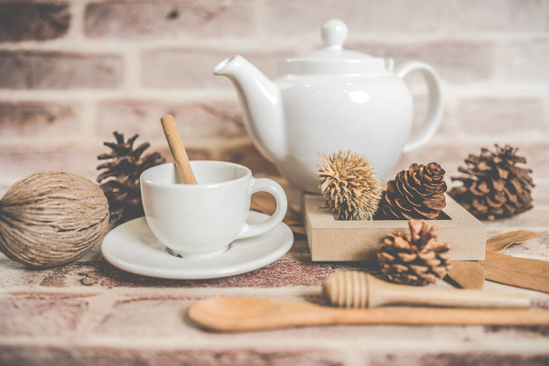 Conceito de chá, bule branco com xícara de chá branco com folhas secas no fundo de madeira, vista de lado. produto orgânico da natureza para saudável com tradicional. - Foto, Imagem