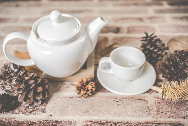 Tea concept, white teapot with white tea cup with dry leaves on wooden background, view from side. organic product from the nature for healthy with traditional. - Foto, Bild