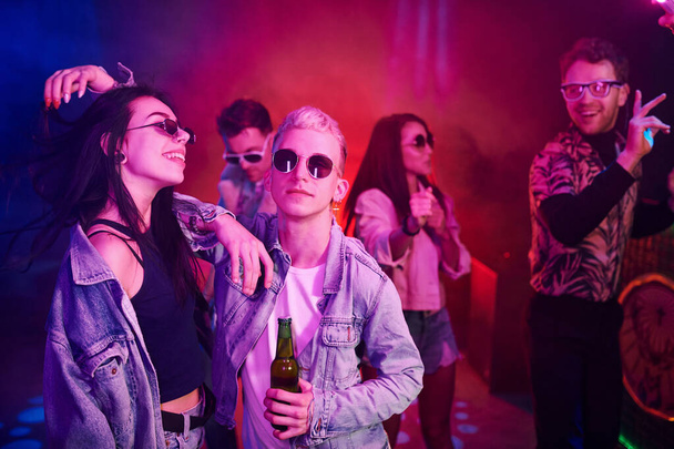 Young people is having fun in night club with colorful laser lights. - Фото, зображення