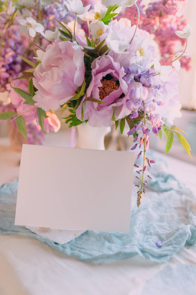 maqueta de una hoja de papel para una firma o una tarjeta para unas vacaciones con un ramo de flores - Foto, imagen