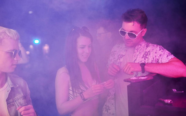 Young people sniffing drug in nightclub with colorful laser lights. - Φωτογραφία, εικόνα