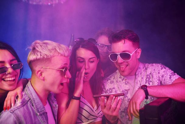 Young people sniffing drug in nightclub with colorful laser lights. - Photo, image