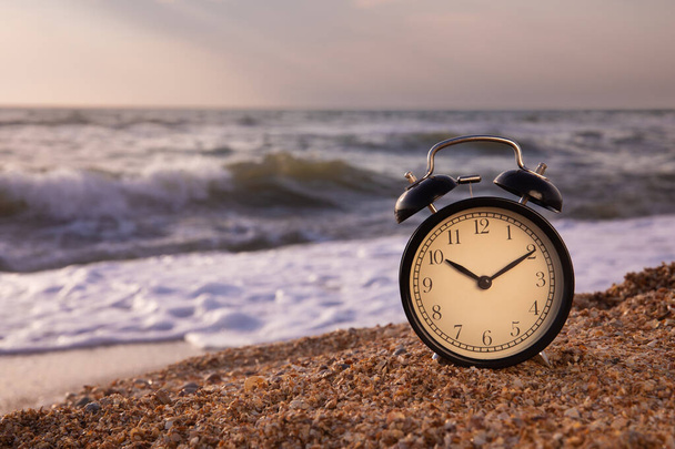 Summer vacation concept. Time to relax. copy space. The concept of an alarm clock on the beach. - Fotografie, Obrázek
