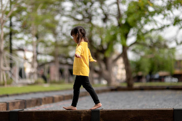 Aziatisch kind meisje spelen op de speelplaats in de outdoor park.Happy moment en goede emotie - Foto, afbeelding