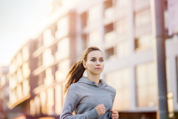Female runner is jogging in the street - Foto, imagen