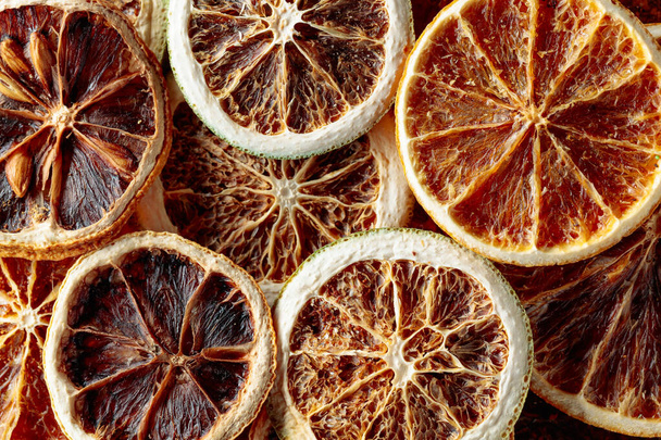 Αποξηραμένο φόντο φέτες πορτοκαλιού. Αφυδατωμένες τραγανές φέτες φρούτων. Μια στοίβα από λιαστά τραγανά πορτοκάλια. Υγιεινό σνακ. Άνω όψη. - Φωτογραφία, εικόνα