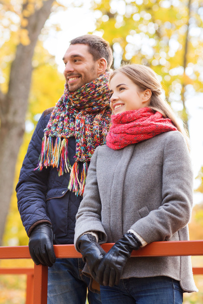 smiling couple hugging on bridge in autumn park - Φωτογραφία, εικόνα