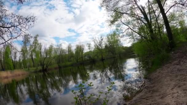 Timelapse of moving clouds. Dynamic footage of clouds over a river in northern Europe. Beach near the river. People are walking in the park. Panoramic timelapse of a landscape in motion. - Felvétel, videó