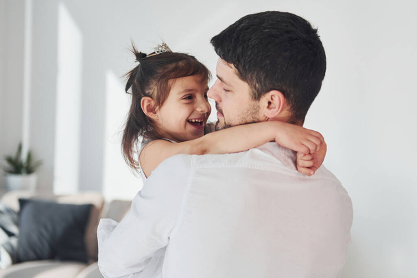 Happy father with his daughter embracing each other at home. - 写真・画像