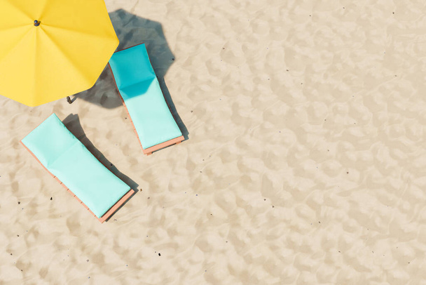 3D иллюстрация удобных шезлонгов с мягкими подушечками, расположенных рядом с желтым зонтиком на песчаном пляже курорта - Фото, изображение