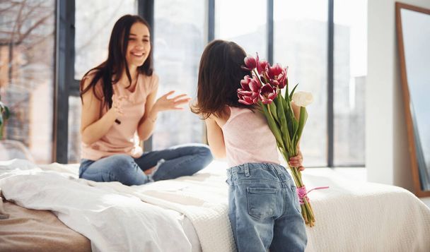 Daughter congratulates mother with holiday and gives bouquet of flowers. - Foto, Imagen