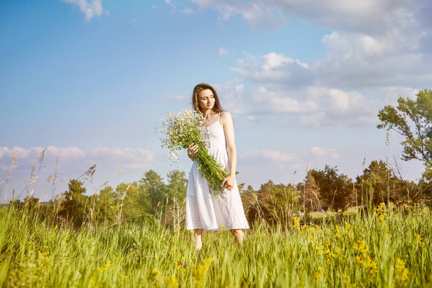girl in a white dress walks in the field - Foto, immagini