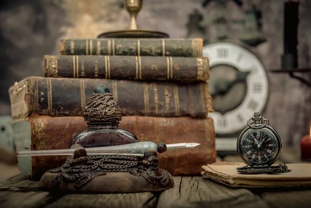 Vintage widok tabeli studiów z książek i złoty zegar z przodu. - Zdjęcie, obraz