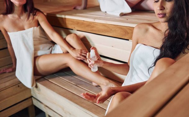 Group of young female friends that lying down and have a rest in the sauna together. Conception of bodycare. - Fotoğraf, Görsel