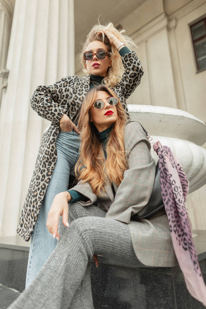 Stylisch schöne junge modische Frauen Freundinnen in trendigen Klamotten in der Stadt - Foto, Bild