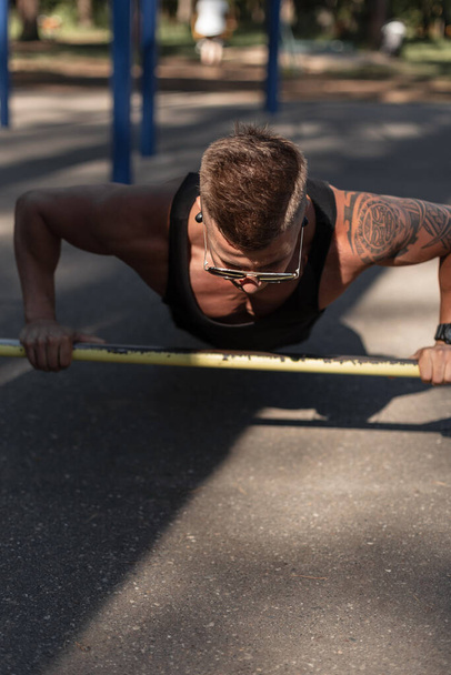 Esportes homem bonito com musculação treino corpo na rua. Cara saudável treina e faz flexões no asfalto - Foto, Imagem