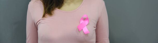 latin woman with pink blouse and pink ribbon for campaign against breast cancer on white background - Фото, изображение