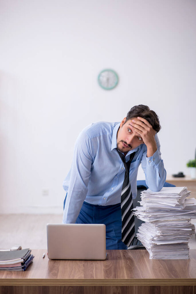Jeune employé masculin mécontent du travail excessif au bureau - Photo, image