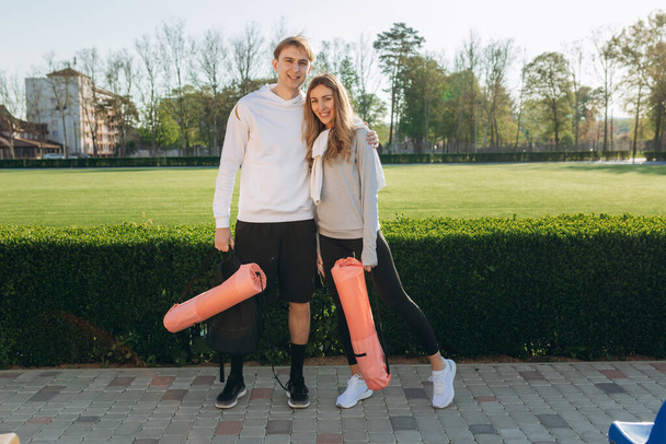 Portrait of young sports couple, in sportswear, came to workout outdoors with sports equipment, sports, healthy lifestyle - Photo, image