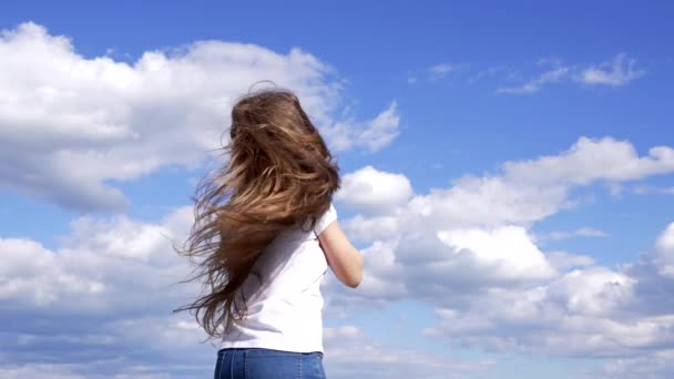 ευτυχισμένο παιδί δείχνουν μακριά μαλλιά απολαύσετε τον ήλιο στο φόντο του ουρανού, κίνητρο - Πλάνα, βίντεο