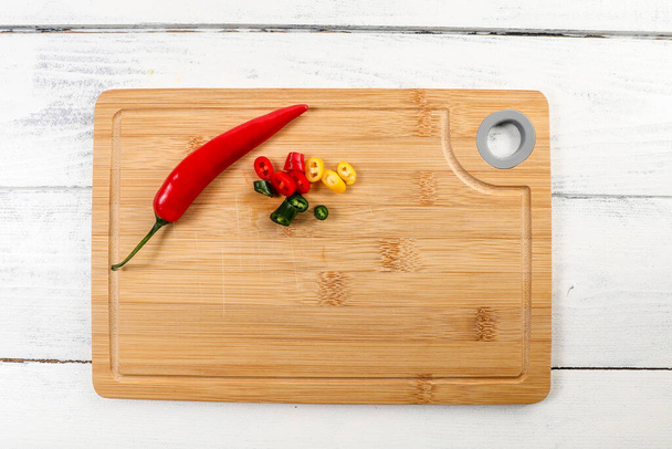 Colored, sliced hot peppers on a bamboo cutting board - Fotografie, Obrázek