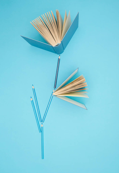 Pastel blue books and pencils on bright blue background. Education, knowledge or Nature concept. Flat lay. - Fotó, kép