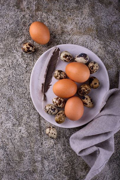 Chicken and quail raw eggs on stone background - Fotografie, Obrázek