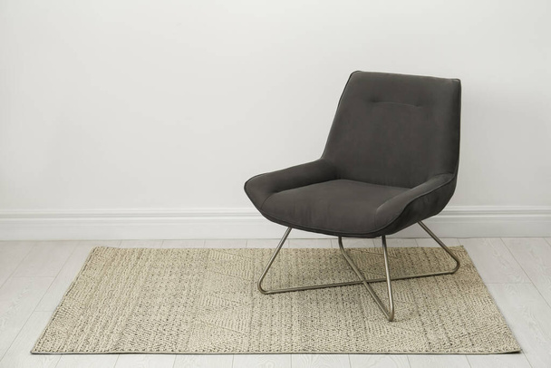 Stylish grey armchair near white wall indoors. Space for text - Fotó, kép