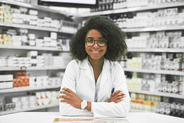 ¿Qué hay en el menú de hoy. Retrato de una joven y alegre farmacéutica de pie con los brazos cruzados mientras mira a la cámara en una farmacia. - Foto, imagen