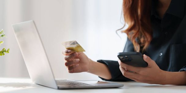 Mujer que utiliza el pago en línea y la celebración de tarjeta de crédito. Concepto de compras online. - Foto, imagen
