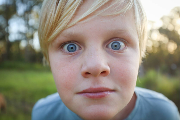 Extrémní zblízka blond běloch chlapec s velkýma modrýma očima s pihami - Fotografie, Obrázek
