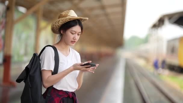 Pretty Young traveler woman excite and planning trip at train station. Summer and travel lifestyle concept. - Video, Çekim