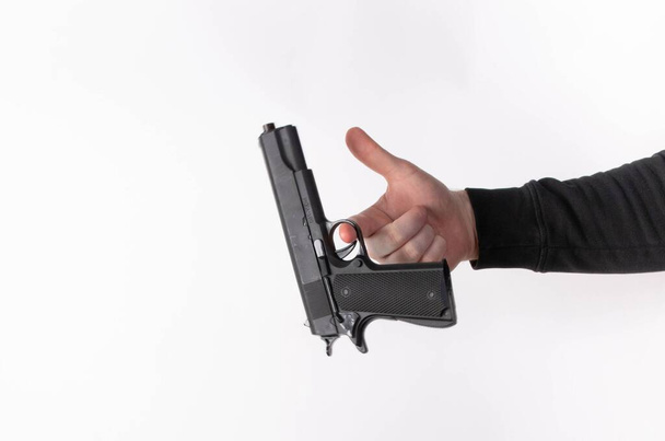 Мужская рука держит пистолет, изолированный на белом - Фото, изображение