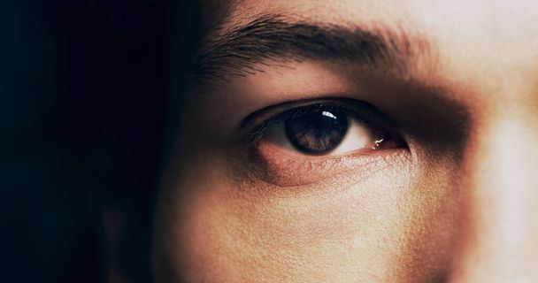 His eyes always tell a story. Closeup shot of man opening his eyes against a dark background. - Foto, imagen