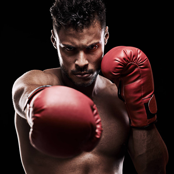 Do or do not - there is no try. Portrait of a young man wearing boxing gloves against a black background. - 写真・画像