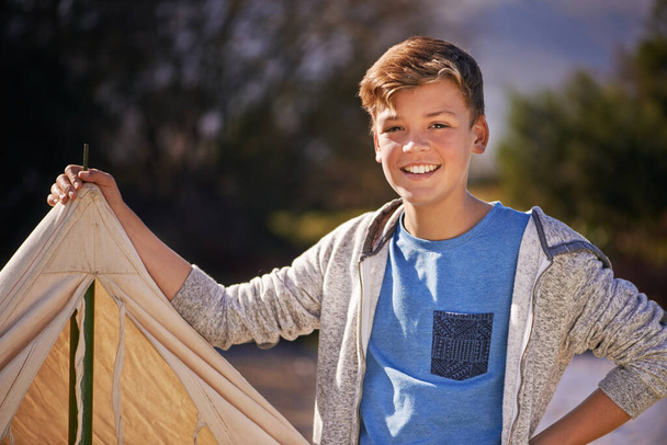 Le camping est le meilleur. Prise de vue d'un jeune garçon dressant sa tente lors d'un voyage en camping. - Photo, image