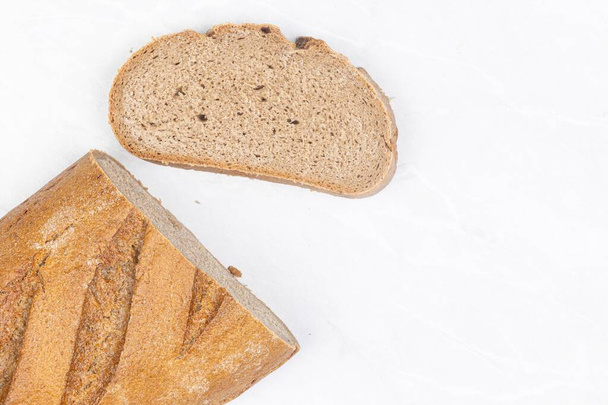 Donker brood met ongezuurd deeg op tafel met kopieerruimte - Foto, afbeelding