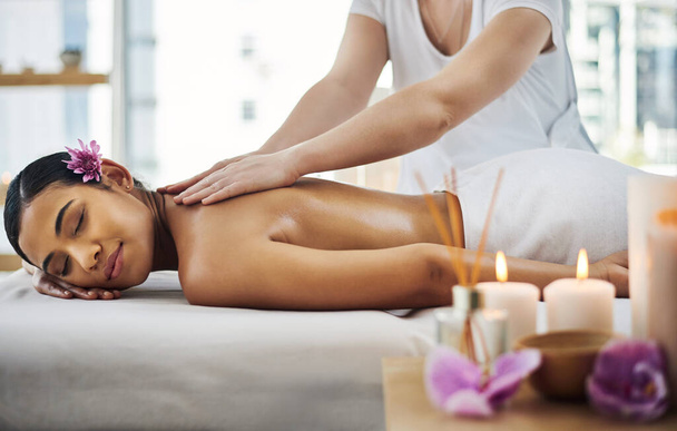 Occupe-toi d'abord de ce massage. Prise de vue d'une jolie jeune femme se faisant masser dans un spa. - Photo, image