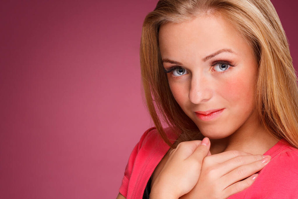 Fashion portrait of elegant young woman with curly blonde hair over pink background - Zdjęcie, obraz