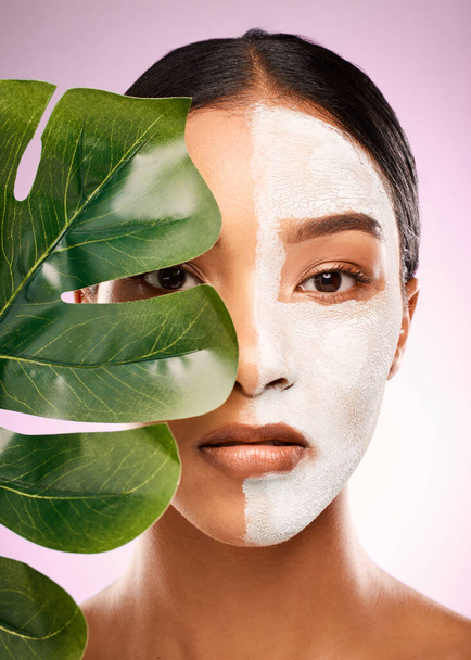 Mother Nature makes my beauty products. Studio shot of an attractive young woman holding a plant and having a facial against a pink background. - Foto, Imagem