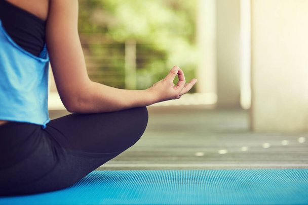 Lo yoga è il modo di vivere. Colpo ritagliato di una giovane donna seduta in posizione loto. - Foto, immagini