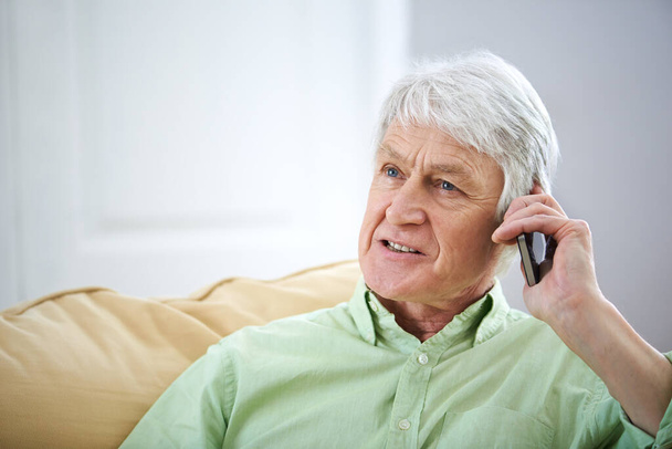 Es war toll, dich wieder einzuholen. Aufnahme eines älteren Mannes, der zu Hause mit seinem Handy spricht. - Foto, Bild