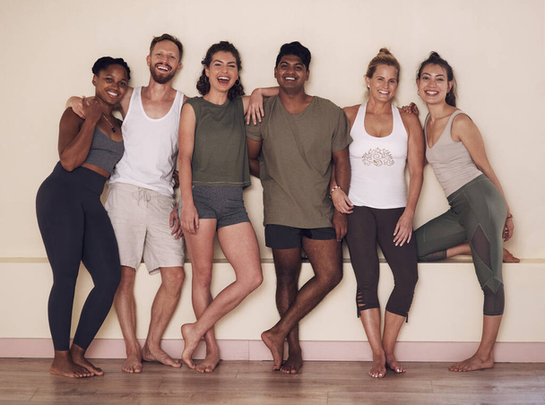Were young, happy and healthy. Full length shot of a group of active young people posing together against a wall in yoga class. - Fotoğraf, Görsel