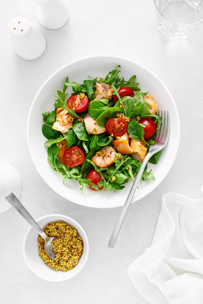 Grilled salmon salad with tomato and salad mix. Top view - Foto, afbeelding