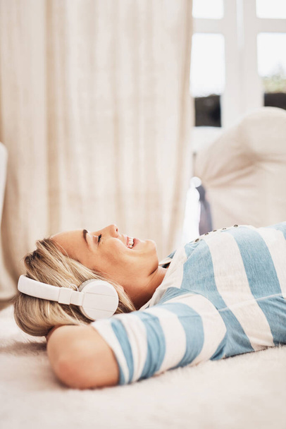 Aujourd'hui, c'est juste pour se détendre. Tournage d'une jeune femme écoutant de la musique tout en se relaxant à la maison. - Photo, image