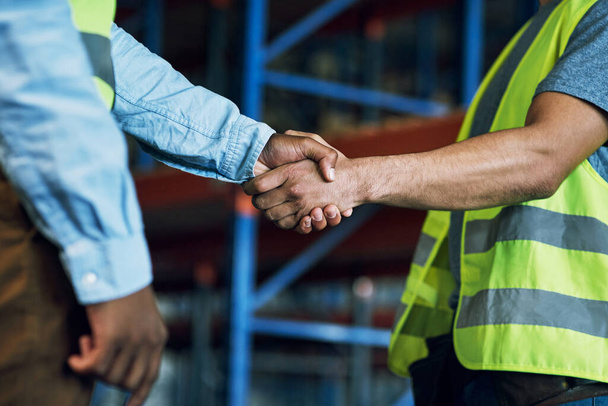 Proud to have a reliable partner like you. Shot of two builders shaking hands at a construction site. - Фото, изображение