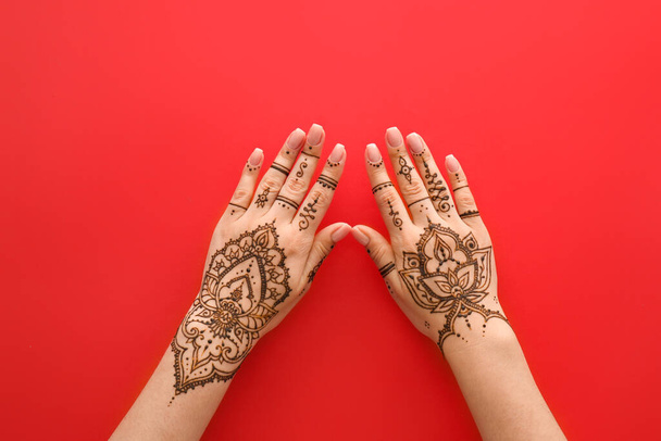 Female hands with beautiful henna tattoo on color background, closeup - Photo, Image